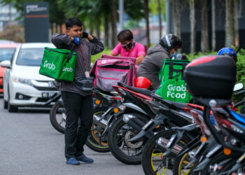 KUALA LUMPUR, MALAYSIA - MARCH 22, 2020 : Food delivery service rider for Foodpanda and GrabFood. Food delivery service through its mobile application.