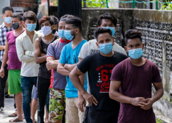 SELANGOR, MALAYSIA - MAY 12, 2020: Foreign migrant workers wearing face mask and lining up before do the COVID-19 screening test at Petaling Jaya. Coronavirus disease 2019 (COVID-19) outbreak.