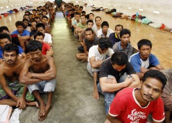 FILE - In this July 23, 2009 file photo, detainees sits in a detention center on the outskirts of Kuala Lumpur, Malaysia. Australia came under fire from the U.N. children's aid agency and human rights advocates Friday June 3, 2011, over its plan to send unaccompanied child asylum seekers to Malaysia under a refugee swap deal being negotiated with the Southeast Asian nation. (AP Photo/Mark Baker,File)