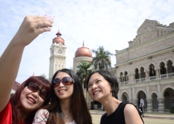Kuala Lumpur 31 Disember 2013 - Tiga pelancong dari Tanah Besar China bergambar dengan penuh gembira sewaktu melawat sekitar kawasan Dataran Merdeka hari ini.