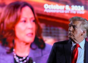 Republican presidential nominee and former U.S. President Donald Trump looks on as a screen shows Democratic presidential nominee U.S. Vice President Kamala Harris during a campaign rally at Macomb Community College in Warren, Michigan, U.S., November 1, 2024. REUTERS/Brian Snyder
