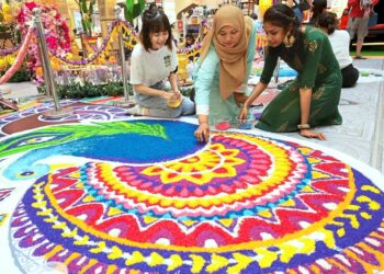 Lecturer Tetriana Ahmed Fauzi (centre) with her students (left) Tay Win Some, 22, and R. Ramya, 22, (right) from Universiti Sains Malaysia, decorating the kolam they designed for Deepavali at Gurney Plaza, in George Town, Penang. ( October 15, 2022 ). — CHAN BOON KAI/The Star