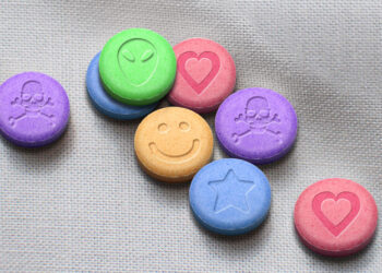 MDMA or Ecstasy pills on white fabric background