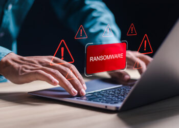 Malware attack virus alert. Person use laptop with virtual warning sign with ransomware word. warning notification, Cyber threats.