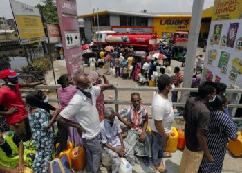 People stand in a long queue to buy kerosene oil for kerosene cookers amid a shortage of domestic gas due to country's economic crisis, at a fuel station in Colombo, Sri Lanka March 21, 2022. REUTERS/Dinuka Liyanawatte