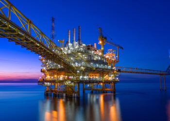 Offshore oil and gas central processing platform in sunset, petroleum business for worldwide energy.