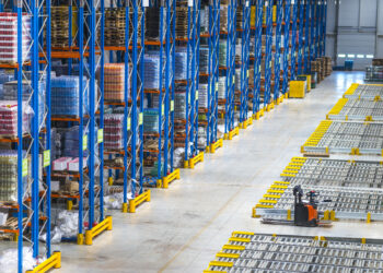 Distribution warehouse building interior and large storage area with goods on the shelf.