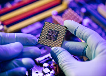 Laboratory technician holds a powerful processor in his hands. CPU computer processor shallow focus. CPU socket of the computer's motherboard. Concept of computer, motherboard, hardware and technology