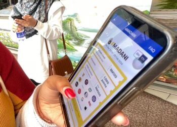 A ladies Pavithra Shree, 24, (left) with her friend Nur Adnisofea,24, claim their eMADANI using their handphone.  FAIHAN GHANI/The Star