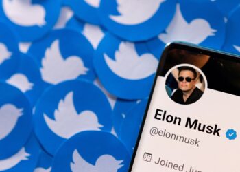Elon Musk's Twitter profile is seen on a smartphone placed on printed Twitter logos in this picture illustration taken April 28, 2022. REUTERS/Dado Ruvic/Illustration