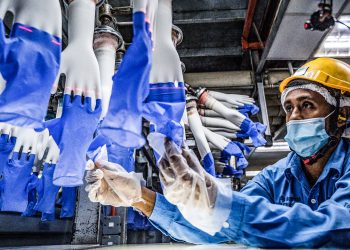 (FILES) In this file photo taken on August 26, 2020, a worker inspects disposable gloves at the Top Glove factory in Shah Alam on the outskirts of Kuala Lumpur. - The US will seize products made by Malaysia's Top Glove after concluding the firm uses forced labour, officials said on March 29, 2021, dealing a fresh blow to the world's biggest surgical glove maker. (Photo by Mohd RASFAN / AFP)