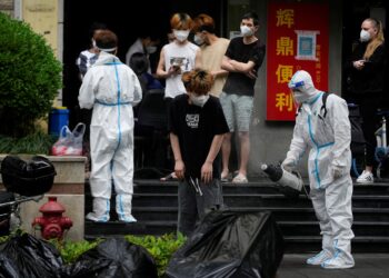 FILE PHOTO: A worker in a protective suit disinfects a person during lockdown, amid the coronavirus disease (COVID-19) outbreak, in Shanghai, China, May 20, 2022. REUTERS/Aly Song