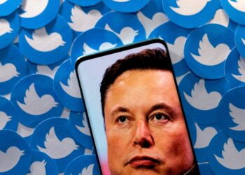 FILE PHOTO: An image of Elon Musk is seen on smartphone placed on printed Twitter logos in this picture illustration taken April 28, 2022. REUTERS/Dado Ruvic/Illustration//File Photo